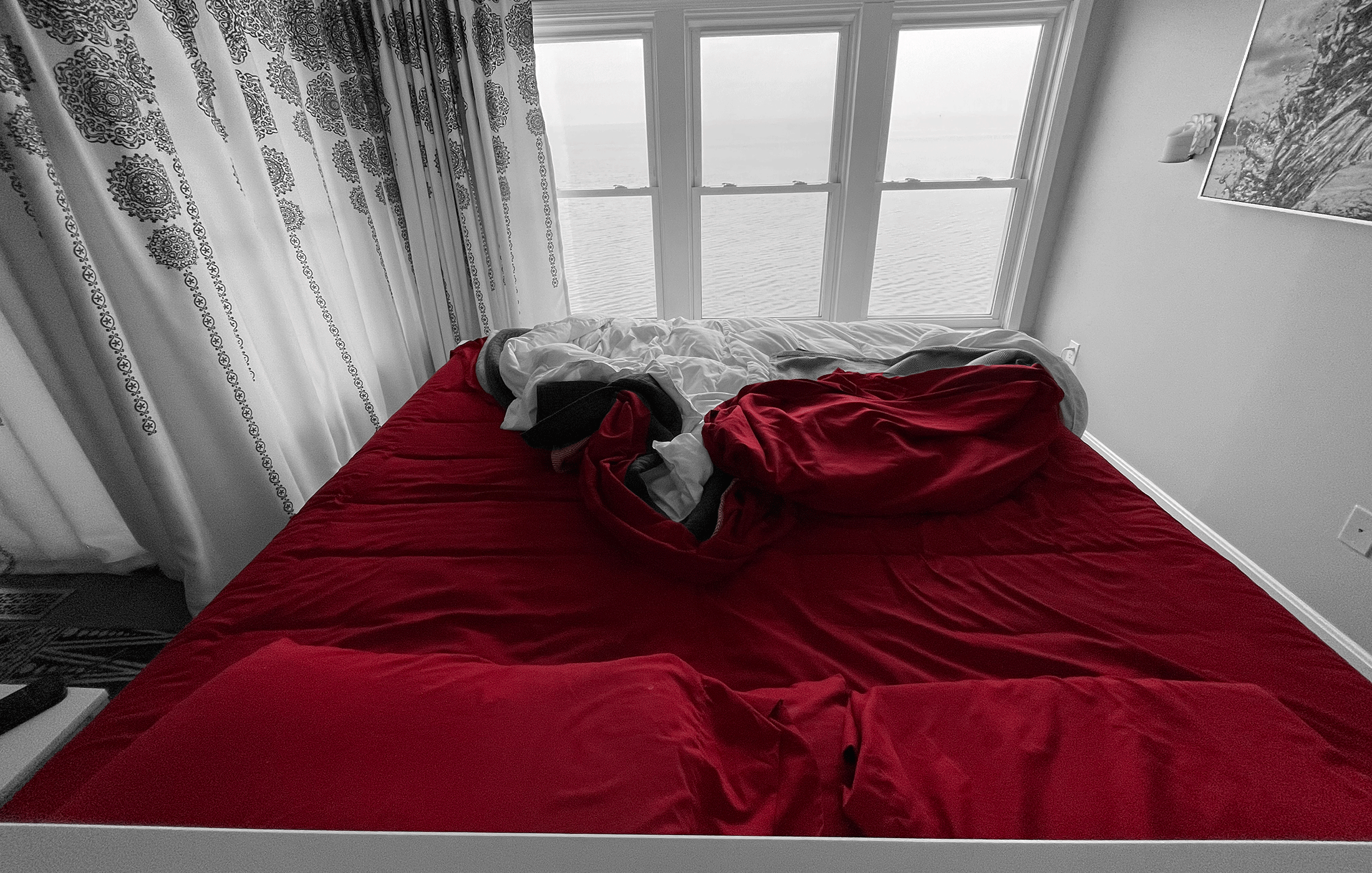 Large bed overlooking the coast with red sheets